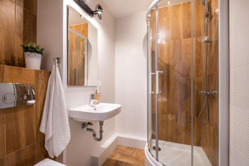 uma casa de banho com um lavatório e um chuveiro em Labo Apartment Metro Plocka em Varsóvia