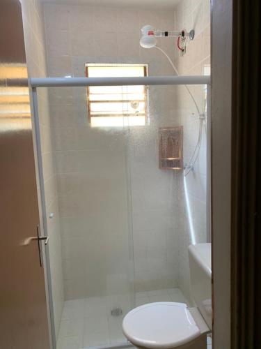 uma casa de banho com um chuveiro, um WC e um lavatório. em Ubatuba - apenas 5 minutos á pé até a praia em Ubatuba
