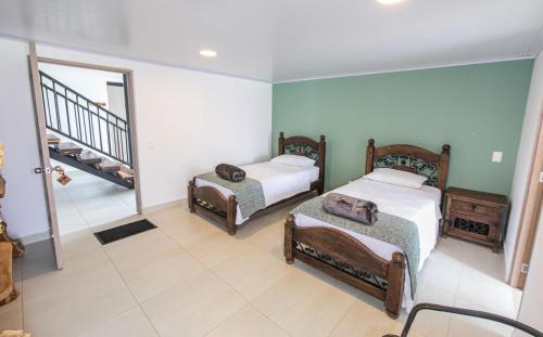 a room with two beds and a staircase at Hotel Hacienda Buena Vista in Pueblo Tapao