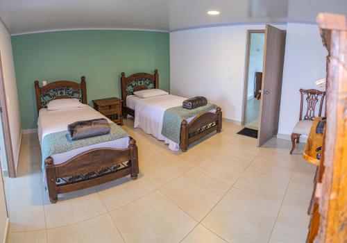 a bedroom with two beds and a mirror at Hotel Hacienda Buena Vista in Pueblo Tapao