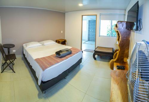 a bedroom with a bed and a chair in it at Hotel Hacienda Buena Vista in Pueblo Tapao