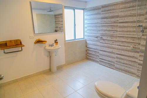 a bathroom with a shower and a toilet and a sink at Hotel Hacienda Buena Vista in Pueblo Tapao