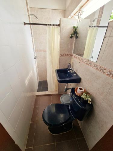 a bathroom with a toilet and a sink at Tatami Hostel in Bucaramanga