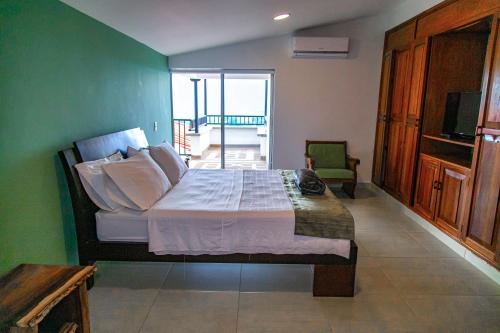 a bedroom with a bed with a green wall at Hotel Hacienda Buena Vista in Pueblo Tapao