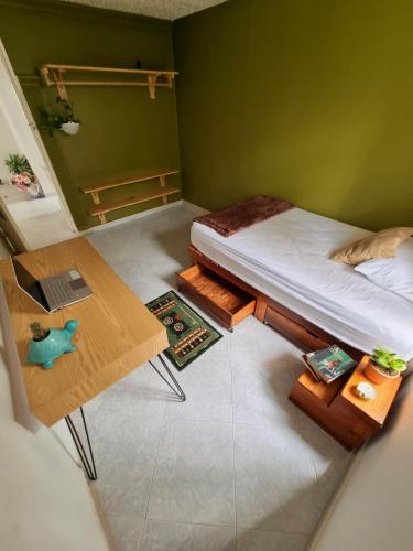 Kleines Zimmer mit einem Bett und einem Tisch in der Unterkunft Tatami Hostel in Bucaramanga