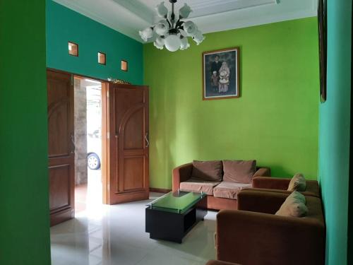a living room with green walls and a couch at Rabbani Family Homestay in Yogyakarta