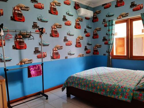 a bedroom with a blue wall with cars on the wall at Rabbani Family Homestay in Yogyakarta