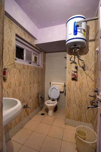 a bathroom with a toilet and a tub and a sink at Hotel Atithi Mall Road in Shimla
