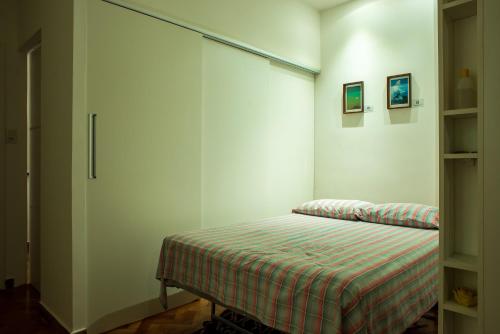 a bedroom with a bed with a striped blanket at Apê da Cassandra em Copa in Rio de Janeiro