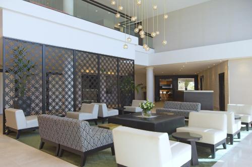 a lobby with white chairs and tables in a building at Sofitel Noosa Pacific Resort in Noosa Heads