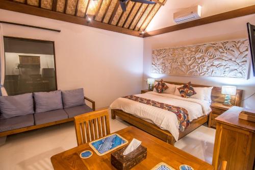 a bedroom with a bed and a couch at Bali Santi Bungalows in Candidasa