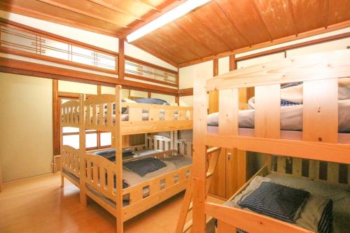 a room with four bunk beds in a house at Guesthouse Omoya in Matsuyama