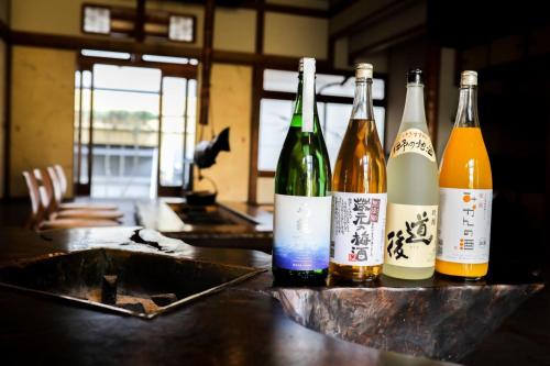 a group of bottles of wine sitting on a counter at Guesthouse Omoya--全個室--囲炉裏のぬくもりと共にグループの絆を深める古民家宿でゆっくりとした時間を-6名部屋-6名部屋-8名部屋--最大20名-ペット同伴可は一室のみ- in Matsuyama