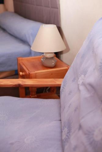 una cama con mesita de noche con una lámpara sobre una mesa en Domaine de la Saule, en Jalogny