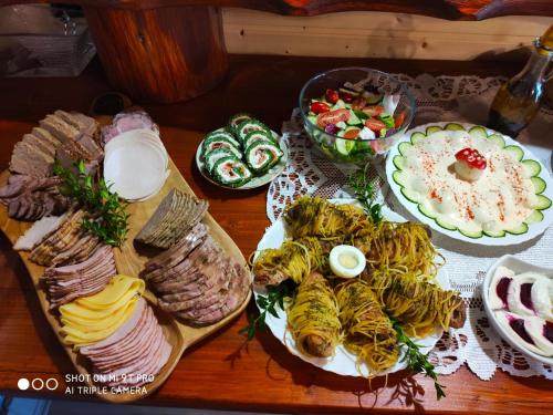 a table with plates of food on a table at Agroturystyka Pod Kołami in Myczkowce