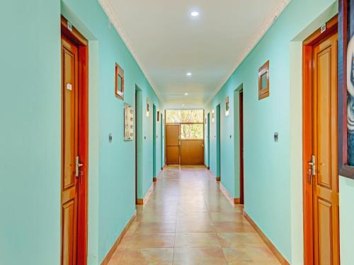 corridoio con pareti blu e pavimento piastrellato di AARAM BEACH RESORT a Kannur