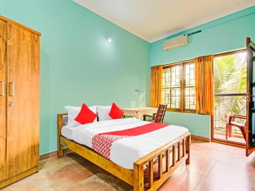 una camera da letto con un letto con cuscini rossi di AARAM BEACH RESORT a Kannur