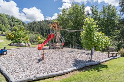 a playground in a park with a slide at Gasserhof - Chalet A in Frassinetto