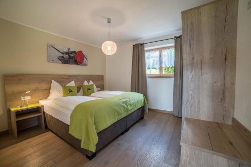 a bedroom with a large bed with a green blanket at Gasserhof - Chalet A in Frassinetto