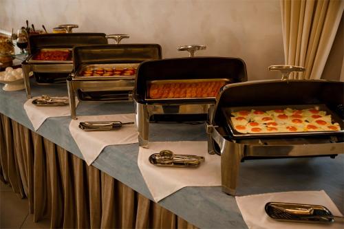 una fila de bandejas de comida sobre una mesa en Park House, en Barmashino