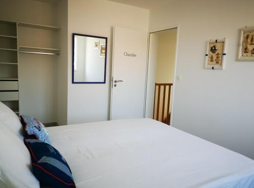 - une chambre avec un lit blanc et une porte dans l'établissement Gîte du Couchant, à Sorède