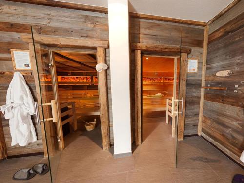 a room with wooden walls and two open doors at Natürlich Hotel mit Charakter in Fiss