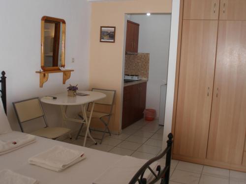Habitación con mesa y cocina con espejo. en Efi Apartments (ΕΦΗ), en Mirina