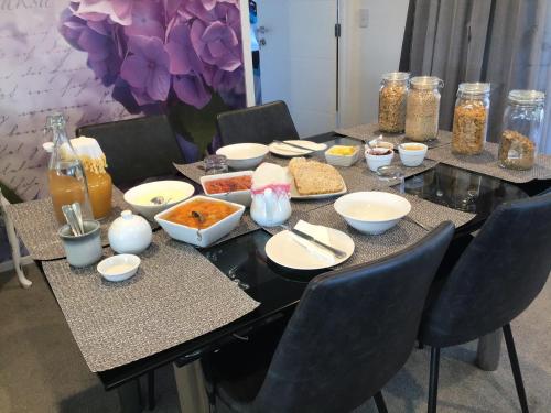 una mesa con comida en ella con sillas y flores en Sabai sabai 27, en Cromwell