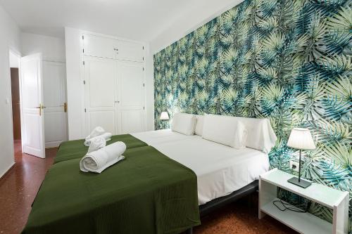 una camera da letto con un grande letto con una coperta verde di MONKÓ CACTUS a Torremolinos