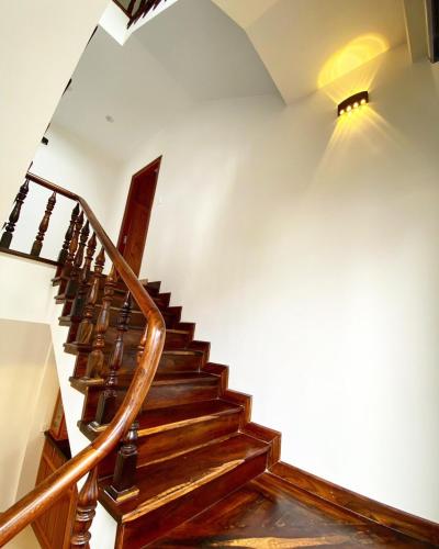 a wooden staircase with a light on the wall at Đà Lạt Villa 84 Hồ Xuân Hương in Da Lat
