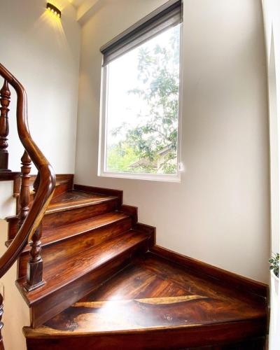 a staircase with wooden floors and a window at Đà Lạt Villa 84 Hồ Xuân Hương in Da Lat