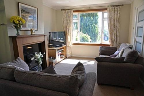 a living room with two couches and a fireplace at Sunny House with views to Edinburgh Skyline in Edinburgh