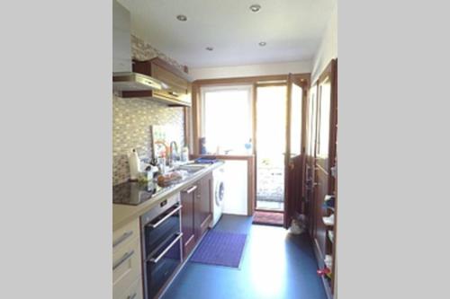 a kitchen with a large window and a sink at Sunny House with views to Edinburgh Skyline in Edinburgh