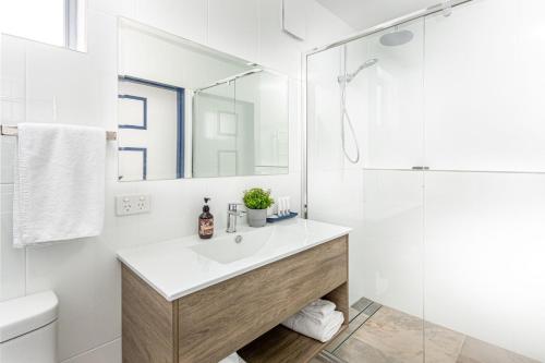 bagno bianco con lavandino e doccia di Granite Belt Motel a Stanthorpe