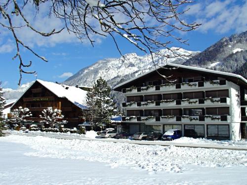 a hotel in the snow with mountains in the background at Chalet Sonne Vandans in Vandans