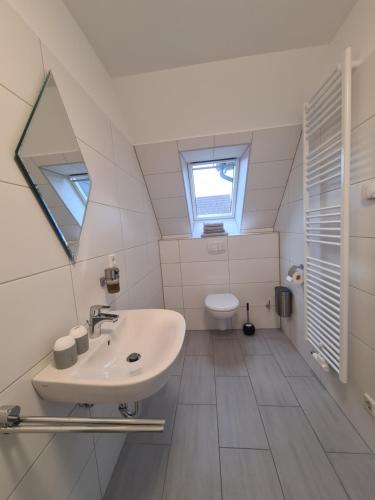 a bathroom with a sink and a toilet at Pension Seeufer Norddeich in Norddeich