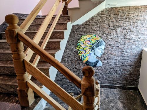 a staircase with a mural of a woman on a wall at Dip Holidays in Shānti Niketan