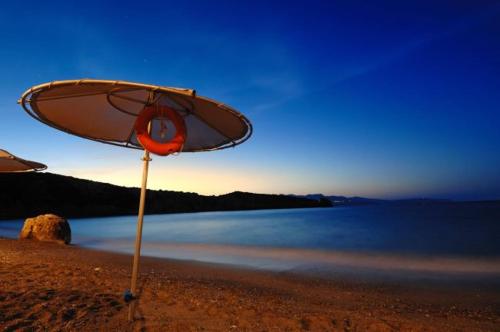 a surfboard sitting on a beach near the water at Istron Bay Hotel in Istron
