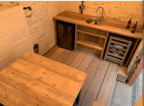 a kitchen with a sink and a wooden table at Ferry Lane Cottage in King's Lynn