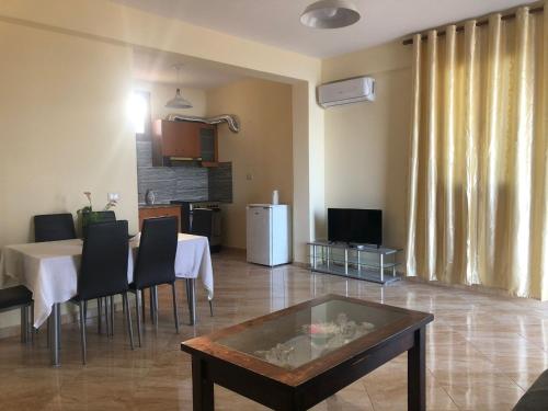 a living room with a table and chairs and a kitchen at The Sunset Villa Leven in Vlorë