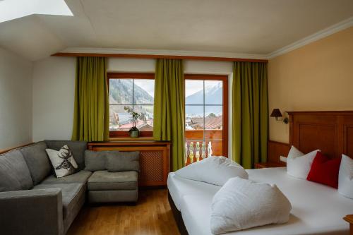 a hotel room with a bed and a couch at Landhaus Severin in Neustift im Stubaital