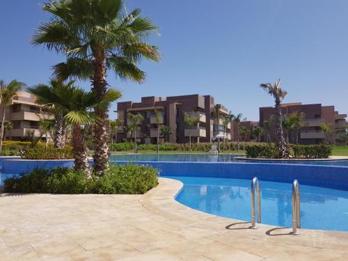 una piscina con palmeras y edificios en Prestigia 16, en Marrakech