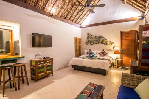 a bedroom with a bed and a tv in a room at Bali Santi Bungalows in Candidasa