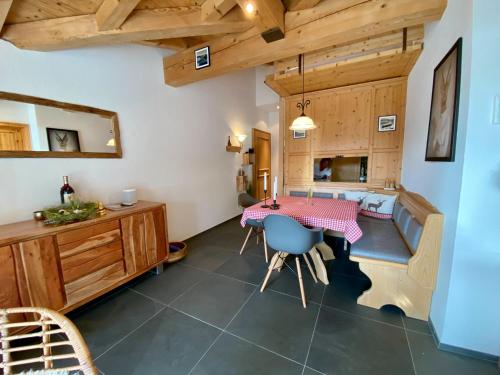 eine Küche und ein Esszimmer mit einem Tisch und Stühlen in der Unterkunft Mira Piz Signina - Ferienwohnung für max. 4 Personen in Laax