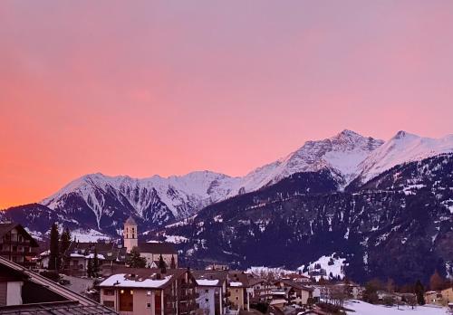 a view of a town with snow covered mountains at Mira Piz Signina - Wunderbare Dachwohnung mit Blick in die Berge in Laax