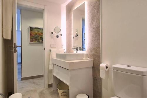 a white bathroom with a sink and a toilet at LUJOSO APARTAMENTO NUEVO PLAYA CENTRO in Estepona