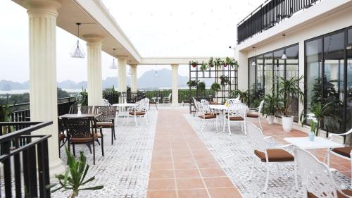 a patio with tables and chairs on a building at ĐTT Galaxy Tam Chúc in Ðục Khê