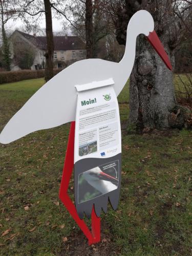 a swan sign in front of a tree at Ediths Haus in Rhauderfehn