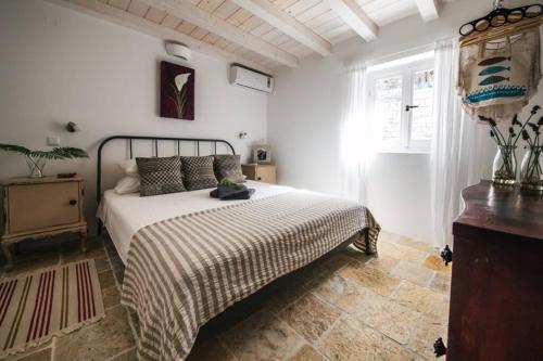 a bedroom with a large bed and a window at Paxos StoneHouse in Gaios