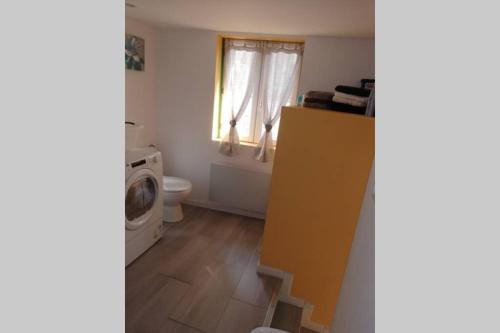 a bathroom with a washing machine and a window at COPACABANA in La Fère